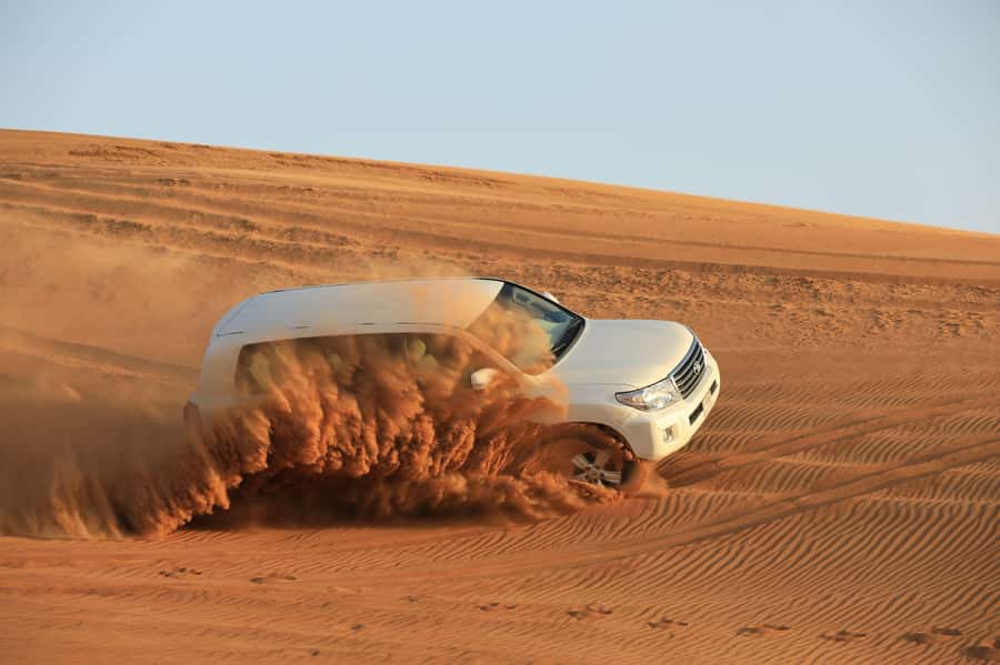 Dubai: Desert Safari, Quad Bike, Sandboarding, Camels & BBQ - Camel riding, sunset photos, and camp traditions