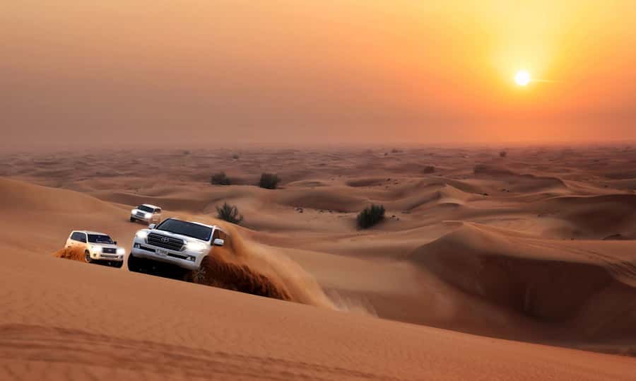 Dubai: Red Dune Desert Safari, Quad Bike, Camels, and BBQ - Sandboarding down the red dunes